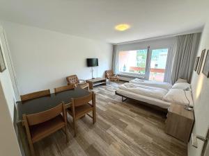 a bedroom with a bed and a table and a window at Mayenzett 33 in Leukerbad
