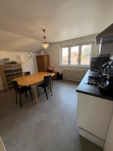 a kitchen with a wooden table and a dining room at L'Appart Sélestadien in Sélestat +14 photos