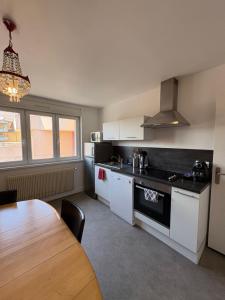 a kitchen with white cabinets and a table in it at L'Appart Sélestadien in Sélestat