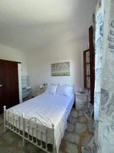 a bedroom with a bed in a white room at Rastoni Apartments Skiathos in Troulos