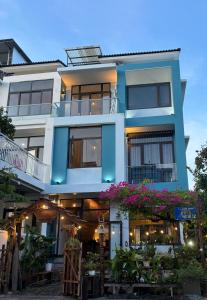 a blue building with flowers in front of it at Lucky coffee & homestay in Thôn Trường Giang