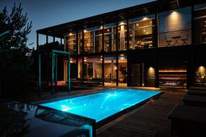 a swimming pool in front of a house at night at Strandvillan Ljunghusen in Ljunghusen