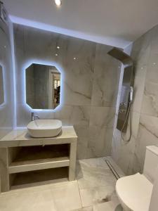 a bathroom with a sink and a shower with a mirror at Rastoni Apartments Skiathos in Troulos +90 photos