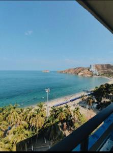 a view of a beach with palm trees and the ocean at ARAWAK 601 Vista al Mar in Rodadero