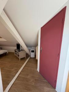 a room with a red door in a attic at L'Appart Sélestadien in Sélestat