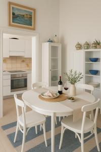 a white kitchen with a white table and chairs at Villa Lina in Castiglioncello