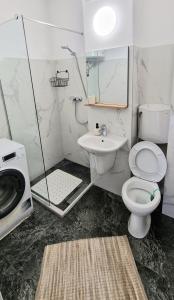 a bathroom with a toilet and a sink and a shower at Apartament Niki in Mangalia +3 photos