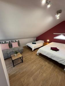 a attic bedroom with two beds and a couch at L'Appart Sélestadien in Sélestat