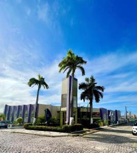a building with palm trees in front of a street at Hotel Costa do Atlantico in Natal +46 photos