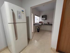 a kitchen with a white refrigerator in a room at Residencial Roma in Palmas