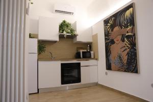 a kitchen with white cabinets and a fireplace at Casa Sant'Anna in Catania