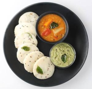 a plate of food with dumplings and a bowl of dip at Hotel Prisha Recidency in Wardha
