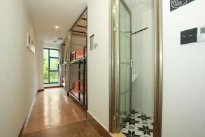 ein Flur mit einer Glastür und schwarz-weiß kariertem Boden in der Unterkunft Dengba International Youth Hostel - Shenzhen Futian Convention and Exhibition Center Branch in Shenzhen