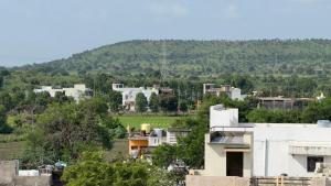 a view of a city with a hill in the background at Hotel Prisha Recidency in Wardha