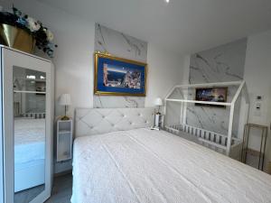 a bedroom with a white bed and a mirror at Szemesbay lakás B 101 in Balatonszemes +22 photos