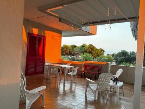 a patio with white chairs and a table and a view at WalMarhouse in Taranto