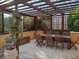 a patio with a wooden pergola with a table and chairs at Alina Villa with shared pool in Montecatini Terme