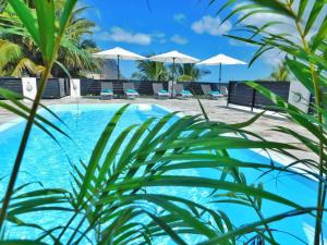 拉戈莱特Coral Studio的配有椅子和遮阳伞的游泳池