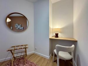 Habitación con espejo, silla y mesa. en La Suite Balinaise, en Quimper