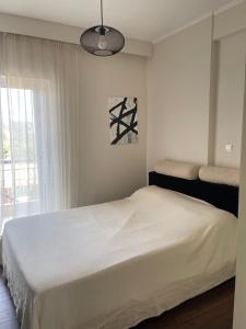 a white bedroom with a bed and a window at Sea view villa in Preveza