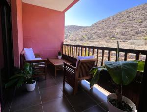 a balcony with chairs and a view of a mountain at Luminoso y Elegante, piscinas y pistas de pádel in Palm-mar
