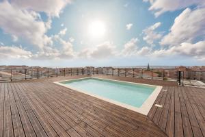 a swimming pool on top of a wooden deck at Consolação Surf & Pool Terrace in Atouguia da Baleia