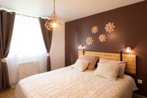 a bedroom with a bed with flowers on the wall at Gîte Chabrignac, jacuzzi et sauna privatif, piscine chauffée partagée, Wifi, salle de jeux in Beynat +31 photos