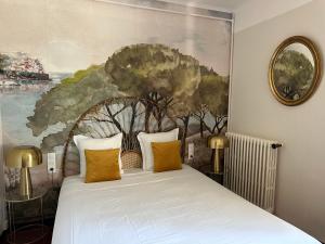 ein Schlafzimmer mit einem Bett und einem Gemälde an der Wand in der Unterkunft Hôtel du Moulin in Allemagne-en-Provence