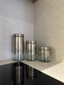 プリシュティナにあるPristina Luxury Apartments 21の部屋の棚に置かれた4つの金属製の容器 +11枚の写真