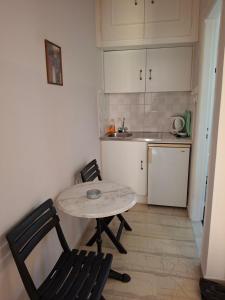 a small kitchen with a table and two chairs at Kabanis Rooms in Ermoupoli