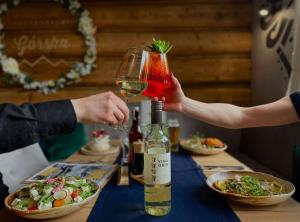 a person holding a glass of wine next to a table at Aparthotel Góralski Spa & Restaurant in Białka Tatrzańska