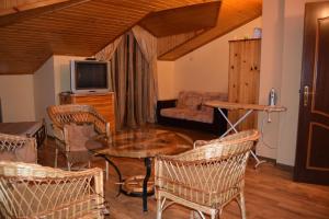 a living room with a table and chairs and a tv at Paradise Bay Villas in Sozopol