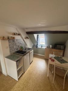 a kitchen with a sink and a table in a room at appartement, en plein coeur de Saint Pierre sur Dives in Saint-Pierre-sur-Dives
