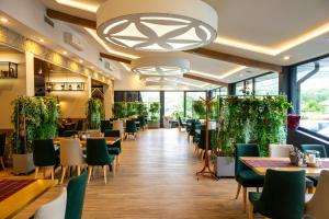 a restaurant with tables and chairs and a chandelier at Zajazd Kałużna zameldowanie do 20 00 in Łącko
