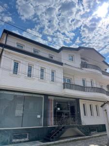 a large white building with a balcony on it at Korca Center Apartment in Korçë