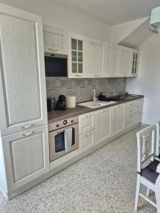 a kitchen with white cabinets and a sink and a stove at Casa ARMANDA 2 in Rivalto