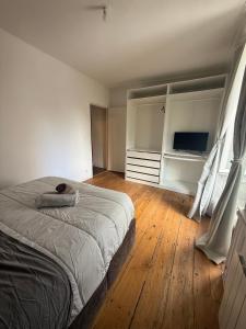 Un dormitorio con una cama y un televisor. en L'ideal, en Vannes
