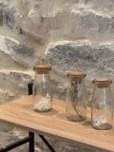 tres frascos de cristal sentados sobre una mesa de madera en L'ideal, en Vannes 2 fotos más