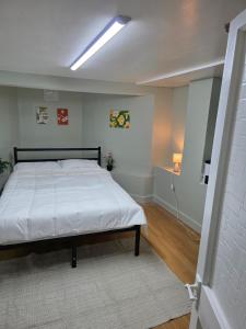 a bedroom with a large bed with a white bedspread at Private Basement Flat in London