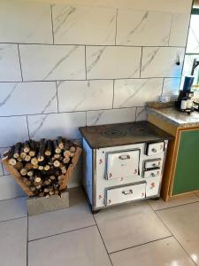 a kitchen with an old stove and a basket of logs at Cabana da Quinta Paraíso in Uruguaiana