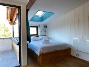 ein Schlafzimmer mit einem Bett und einem großen Fenster in der Unterkunft La Maison de Graviès in Anduze