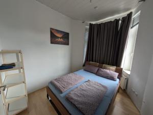 a small bedroom with a bed and a ladder at Zentral gelegene Altbauwohnung in Detmold, Paulinchen in Detmold