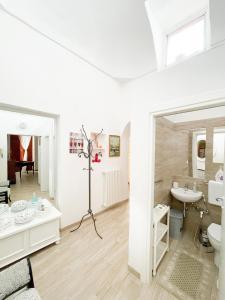 a white bathroom with a sink and a toilet at Casa Patty nel Vicolo in Ostuni