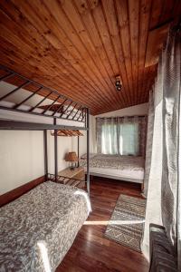 ラカノーにあるGrande Maison Pleine Nature 5 Chambres pour 10 à 12 persの木製の天井が特徴のベッドルーム1室(二段ベッド2組付)が備わります。