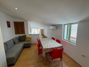 a living room with a table and chairs and a couch at Apartments Valentino by Pag tours in Pag