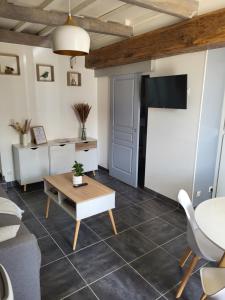 a living room with a table and a tv at Jolie maison cosy en sologne in Romorantin