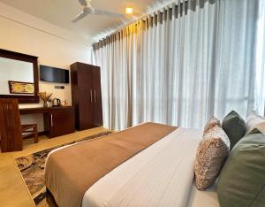 a bedroom with a large bed in front of a window at 360 Viewpoint by Queens Mount in Kandy