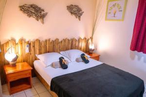 a bedroom with a bed with a wooden headboard at Vacances pieds dans l'eau in Les Trois-Îlets