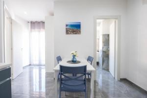 a dining room with a white table and blue chairs at I Due Moli Vibo Marina in Vibo Valentia Marina