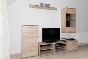 a television on a wooden entertainment center in a room at Big Suit for 4 Adults and 2 Children under 14 years in Hajdúszoboszló